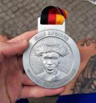 Die R&uuml;ckseite der Finisher-Medaille  in Berlin ist mit dem Olympiasieger 2016, Eliud Kipchoge aus Kenia gepr&auml;gt. Er stellte einen neuen Weltrekord in Berlin auf, was diese Medaille zu einer ganz besonderen macht.