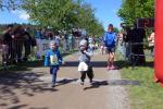 W&auml;hrend „die Gro&szlig;en“ bereits ihren Wettkampf hinter sich hatten, flitzt Linnart (re.) beim Quedel-Lauf der Kindergartenkinder &uuml;ber die Ziellinie. Coach Oma freut sich im Hintergrund.